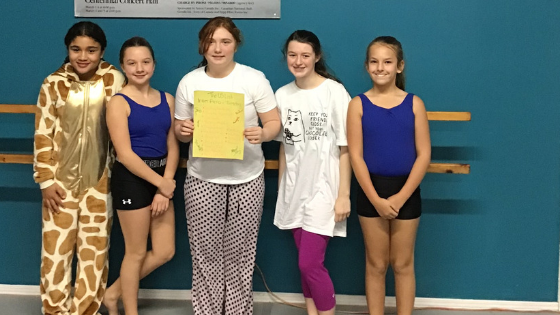 Our Intermediate Acro class posed with their Us List on PJ Day!